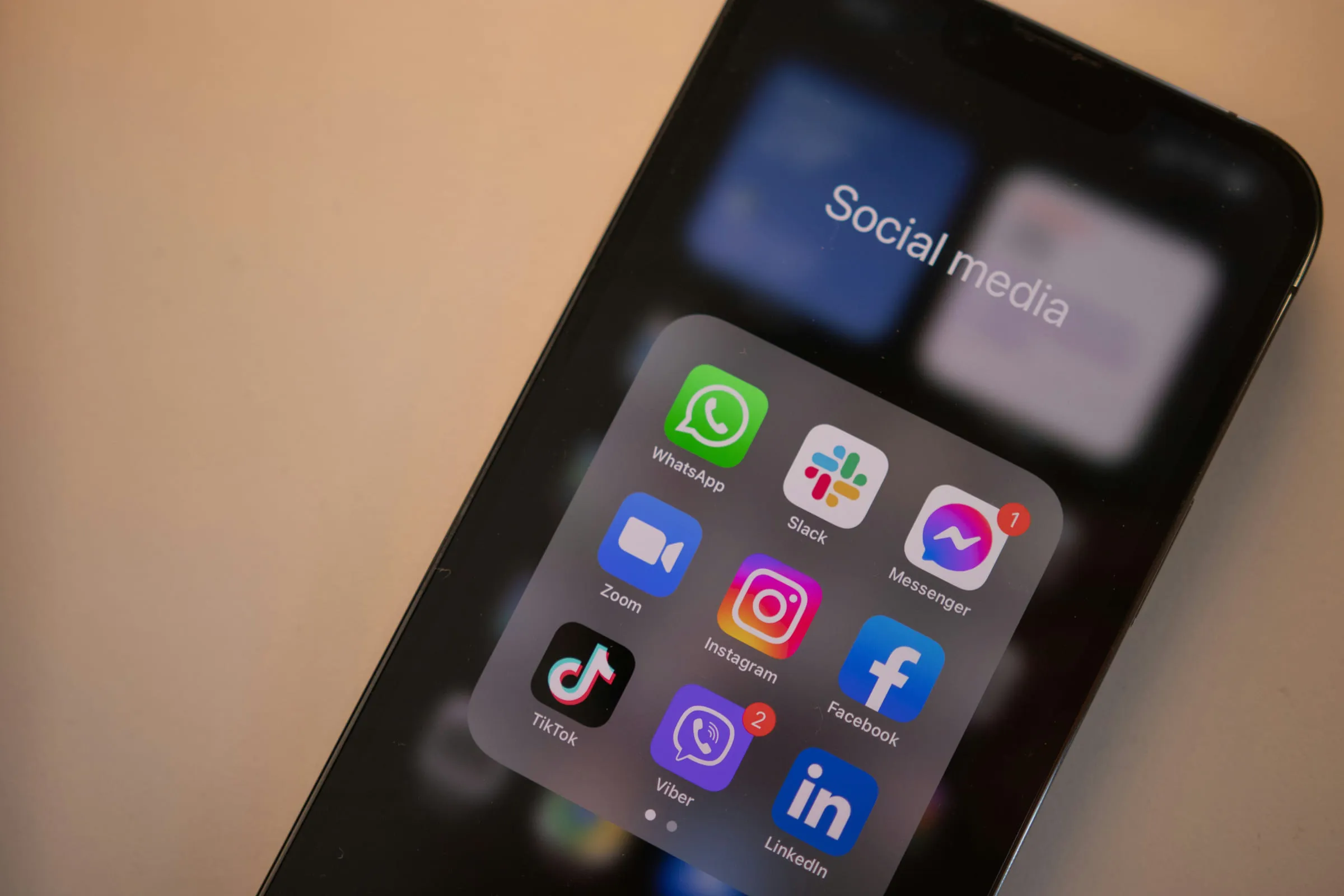 Smartphone mit einem geöffneten Ordner „Social Media“: WhatsApp, Instagram, TikTok, Facebook und LinkedIn nebeneinander.